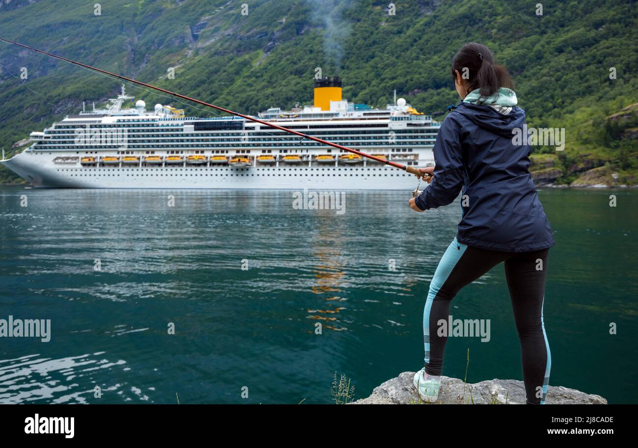 Mujer pesca en caña de pescar spinning en Noruega. La pesca en Noruega es una forma de abrazar el estilo de vida local. Innumerables lagos y ríos y una amplia Foto de stock