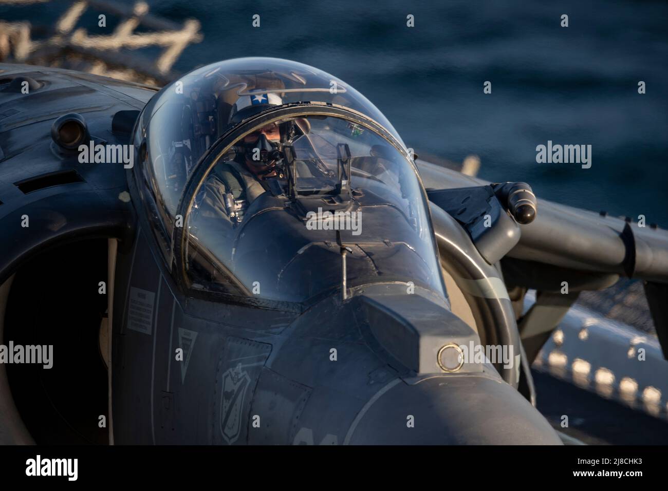 US Marine Corps AV-8B Harrier adjunto al Essex 214 de Black Sheep of Marine Attack, se prepara para el lanzamiento desde la cubierta de vuelo del buque anfibio de asalto USS Essex, clase Wasp, el 21 de marzo de 2021 en el Océano Pacífico. Foto de stock