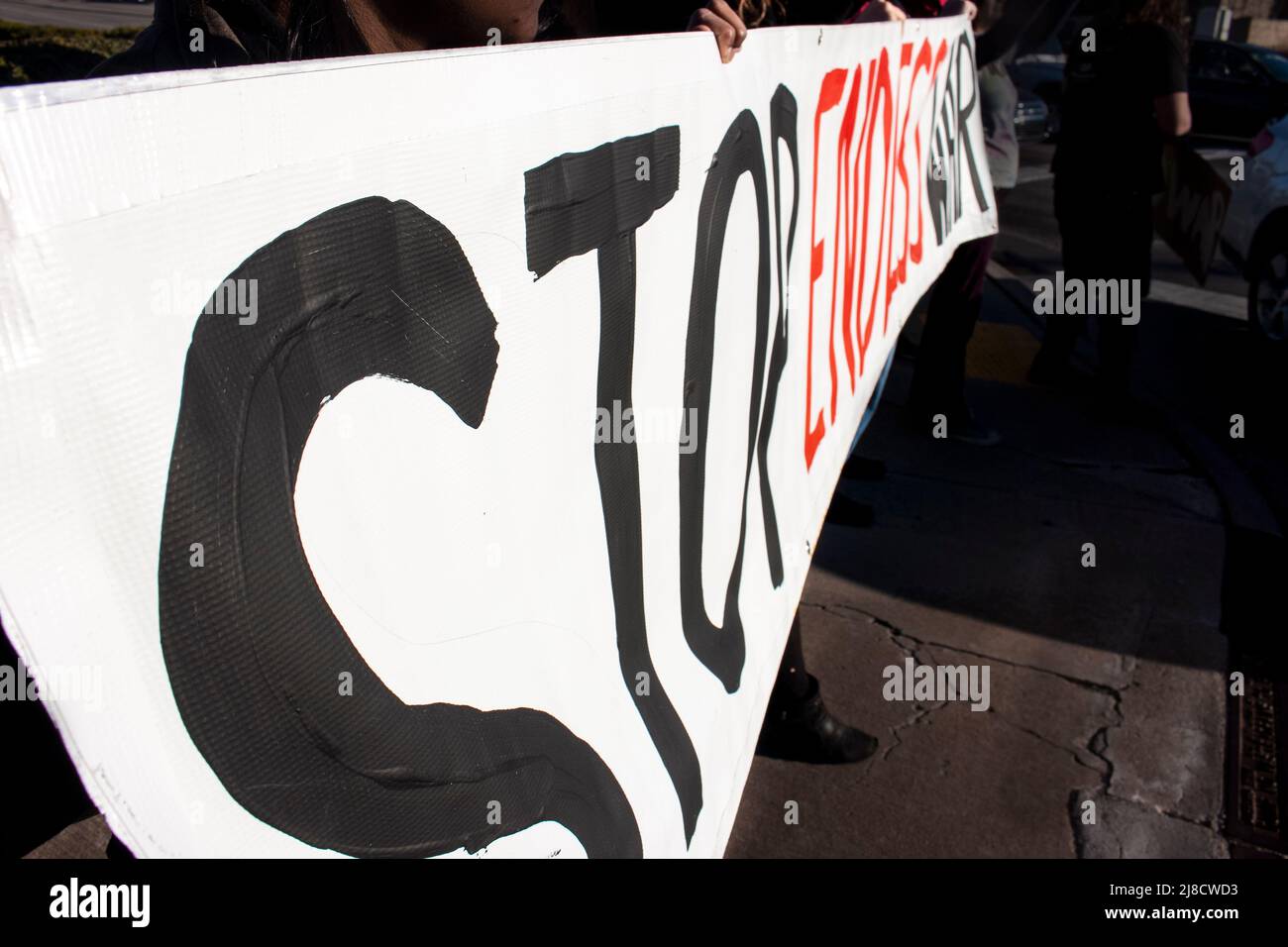 La gente mantiene un signo que dice DETENER UNA GUERRA INTERMINABLE en la protesta contra la guerra de Irán - perspectiva y enfoque selectivo Foto de stock