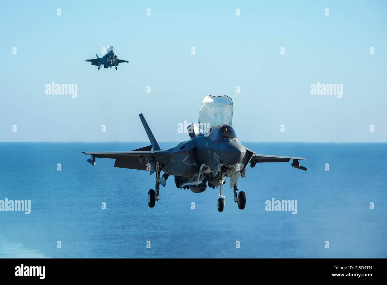 Los aviones de combate del Cuerpo de Marines de los EE.UU. F-35B Lightning II, unidos a los Knightriders of Marine Medium Tiltrotor Squadron 164, se aproximan para un aterrizaje vertical en la cubierta de vuelo del buque anfibio de asalto clase Wasp USS Makin Island, 18 de diciembre de 2020 que opera en el Océano Índico. Foto de stock