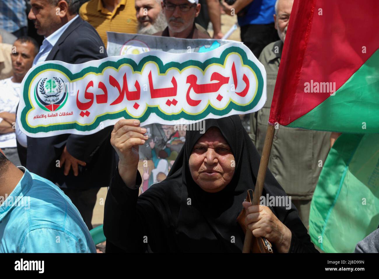 Una mujer palestina tiene un cartel que dice 'volveré a mi pueblo', ya que participa en un mitin que conmemora el 74th aniversario de Nakba, frente a las oficinas de la UNESCO en la ciudad de Gaza. Las facciones palestinas organizan un mitin cada 15th de mayo que marca lo que llaman la 'Nakba', o 'catástrofe', refiriéndose a su desarraigo en la guerra contra la creación de Israel en 1948. Foto de stock