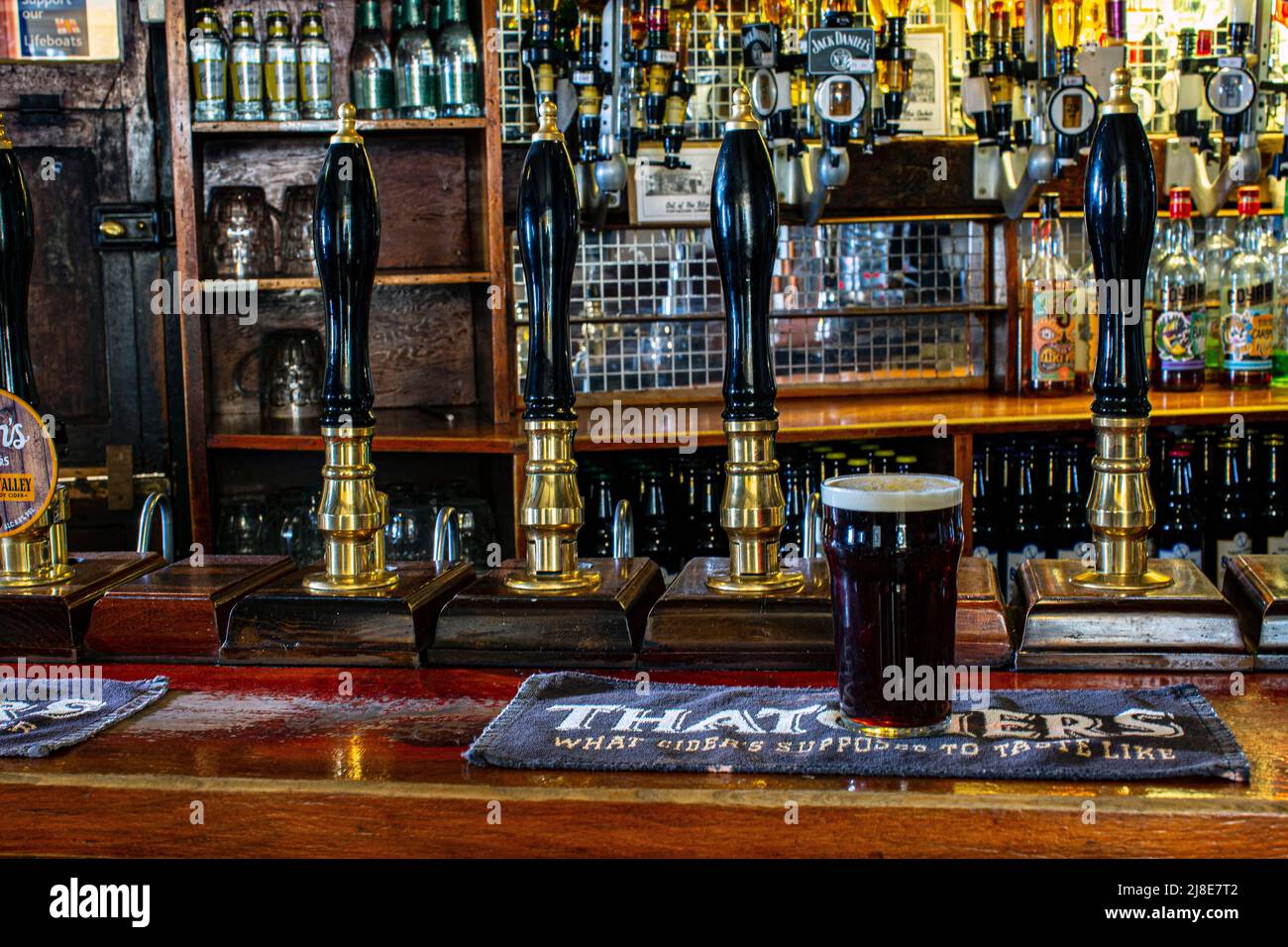 Pinta de vaso de Spingo Ale, sobre una colchoneta de cerveza con bombas de bar en el Blue Anchor Inn en Helston, Cornwall, Reino Unido Foto de stock