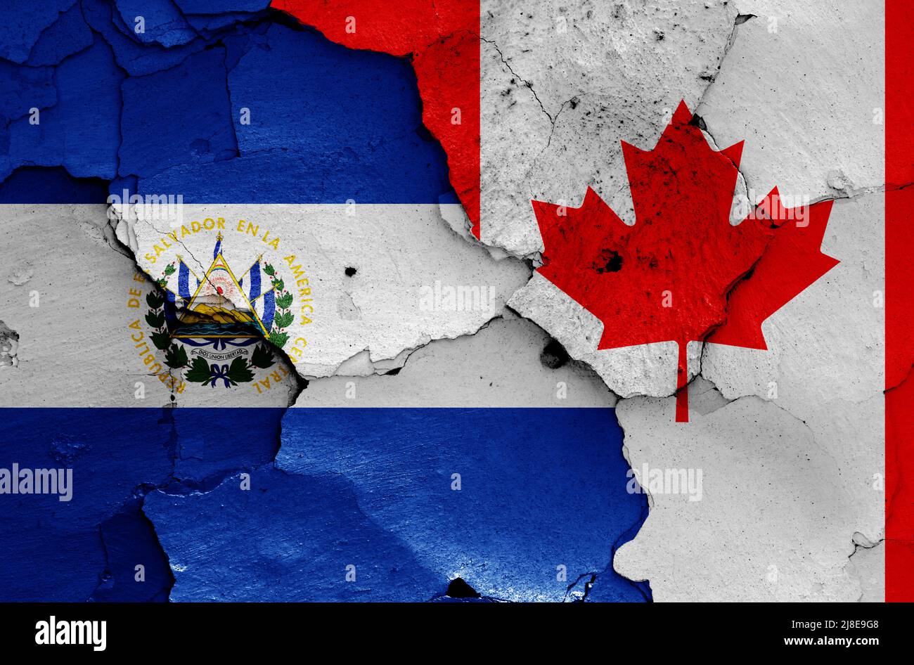Banderas de El Salvador y Canadá pintadas en la pared agrietada Foto de stock
