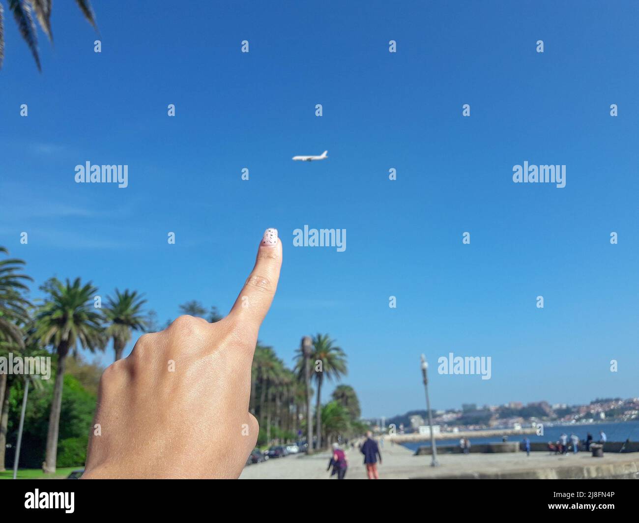 Niña muestra el cielo en su viaje avión que vuela. Foto de stock