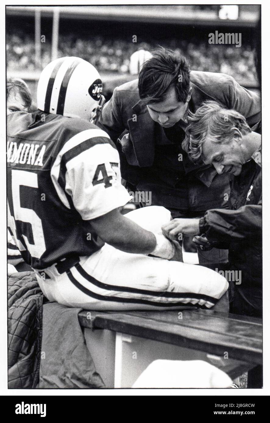 El traumatólogo de los New York Jets, Dr. Robert Grossman, y el entrenador de por largo tiempo, Jeff Snedyker, encinta la muñeca de Lou Giamona corriendo de vuelta al margen de un partido de fútbol de 1976 en el Shea Stadium en la ciudad de Nueva York. Foto de stock