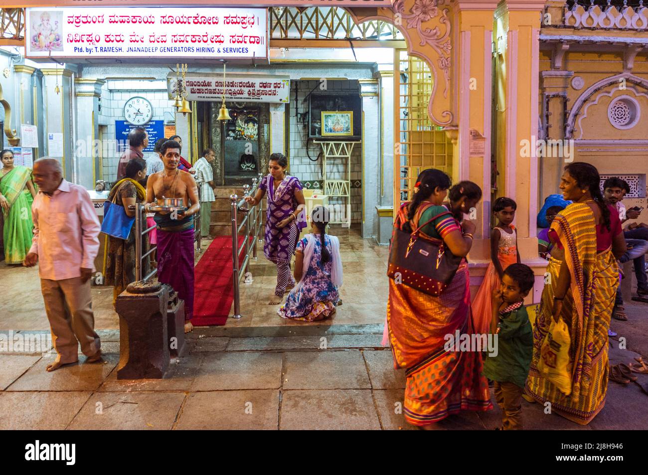 Mysore, Karnataka, India : Un grupo de mujeres se encuentran fuera de un templo en la puerta de Noth del Palacio Mysore Maharaja. Foto de stock