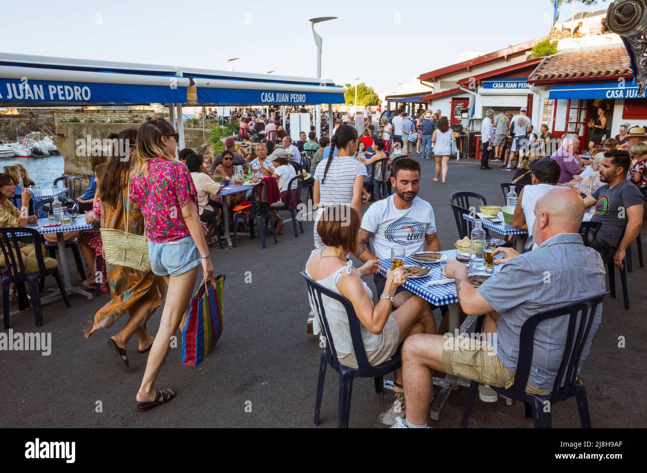 Biarritz, país Vasco francés, Francia - 19 de julio de 2019 : La Gente cena en el restaurante al aire libre Casa Juan Pedro en el puerto pesquero. Foto de stock