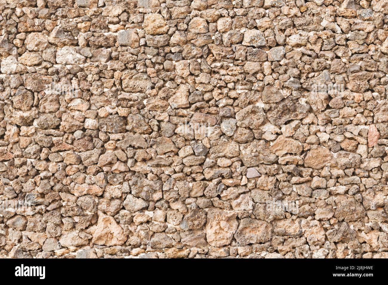 Pared de piedra seca, paredes de piedra seca. Patrón, textura o fondo de repetición (con posibilidad de diezmar) sin fisuras. Foto de stock