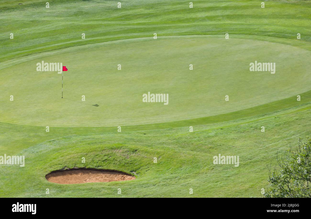 Verde golf con bandera, agujero y búnker, visto desde arriba, vista aérea del campo de golf, Reino Unido Foto de stock