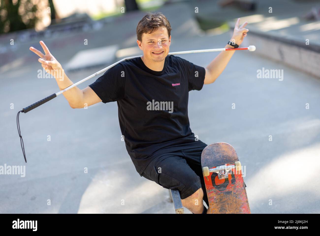 Nuremberg, Alemania. 11th de mayo de 2022. El patinador ciego Johannes  Bruckmeier se sienta en un parque de skate con su palillo ciego y su tabla.  El joven de 27 años de