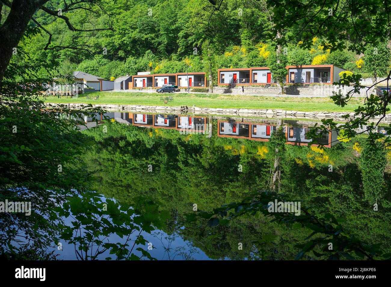 Reflexión sobre el agua de las cabañas en la orilla del río Sure, Cocoon Hotel la Rive, Bourscheid, distrito de Diekirch, Ardenas, Luxemburgo, Europa Foto de stock