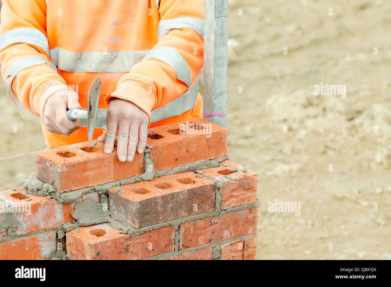 Bricklayer poniendo ladrillos sobre mortero en la construcción de una nueva  casa residencial Fotografía de stock - Alamy