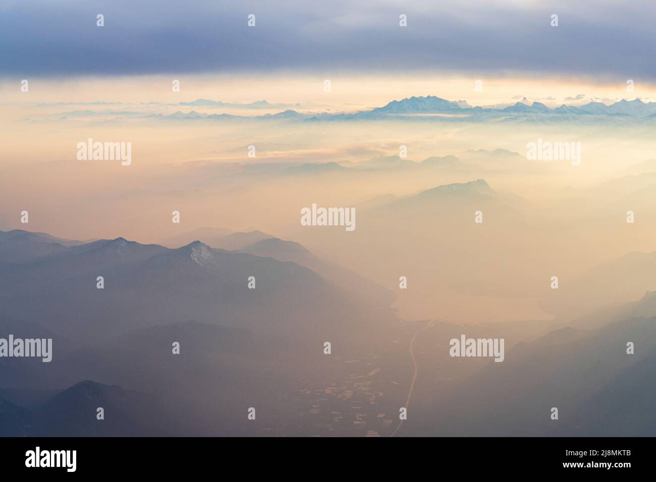 La ciudad suiza de Locarno, el lago Maggiore y Monte Rosa se encuentran en el pico de la niebla al atardecer desde la ventana del avión, los Alpes Lepontinos, Suiza Foto de stock