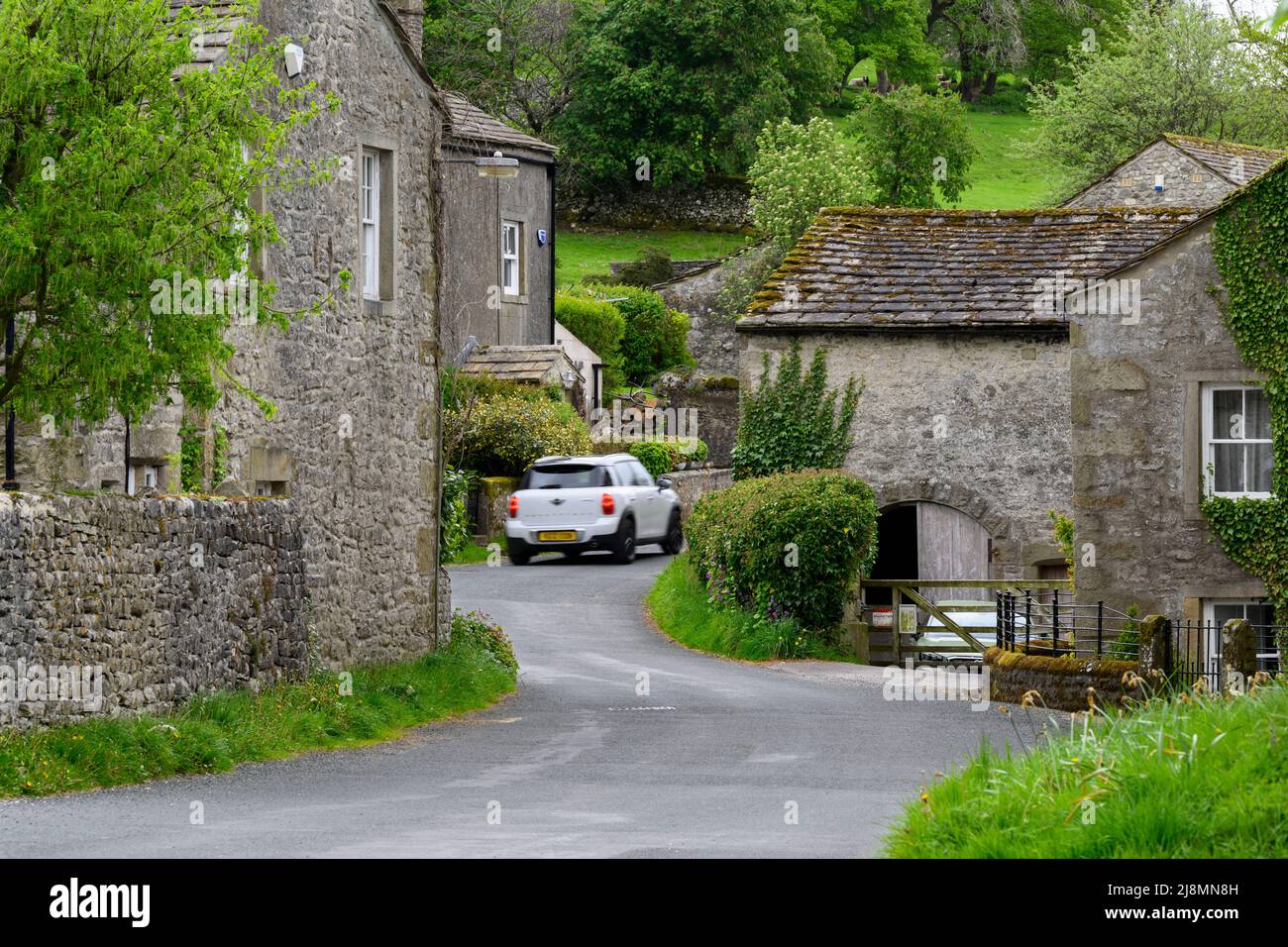 Conistone VILLAGE (hermosos edificios de piedra vírgenes, campos verdes, empinada ladera del valle, coche en carretera) - Wharfedale, Yorkshire Dales, Inglaterra Reino Unido. Foto de stock