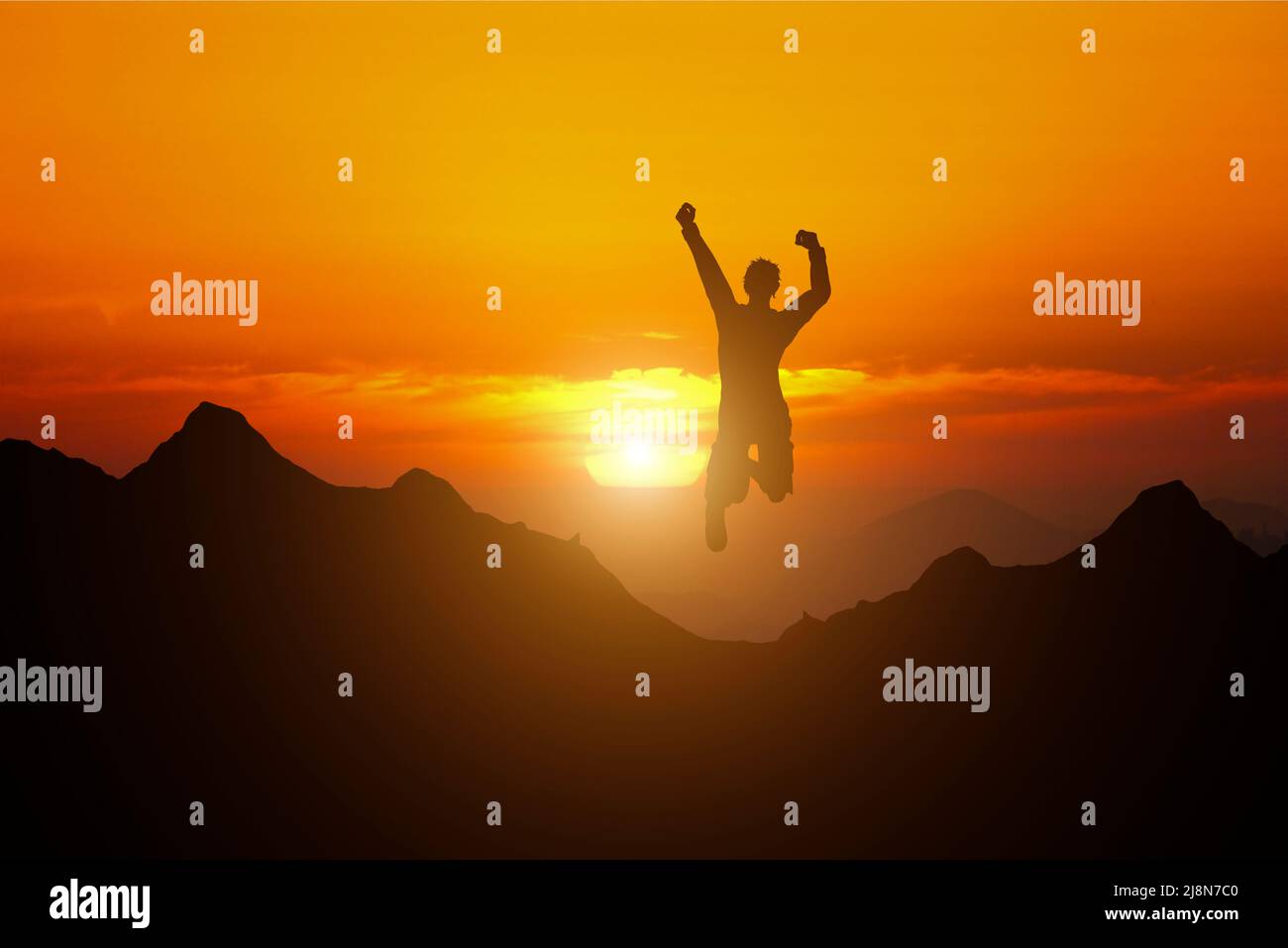 Feliz hombre saltando en la cima de la montaña con el cielo puesta de sol abstracto de fondo. Libertad sentirse bien y el concepto de vacaciones de verano. Efecto de filtro de tono vintage Foto de stock