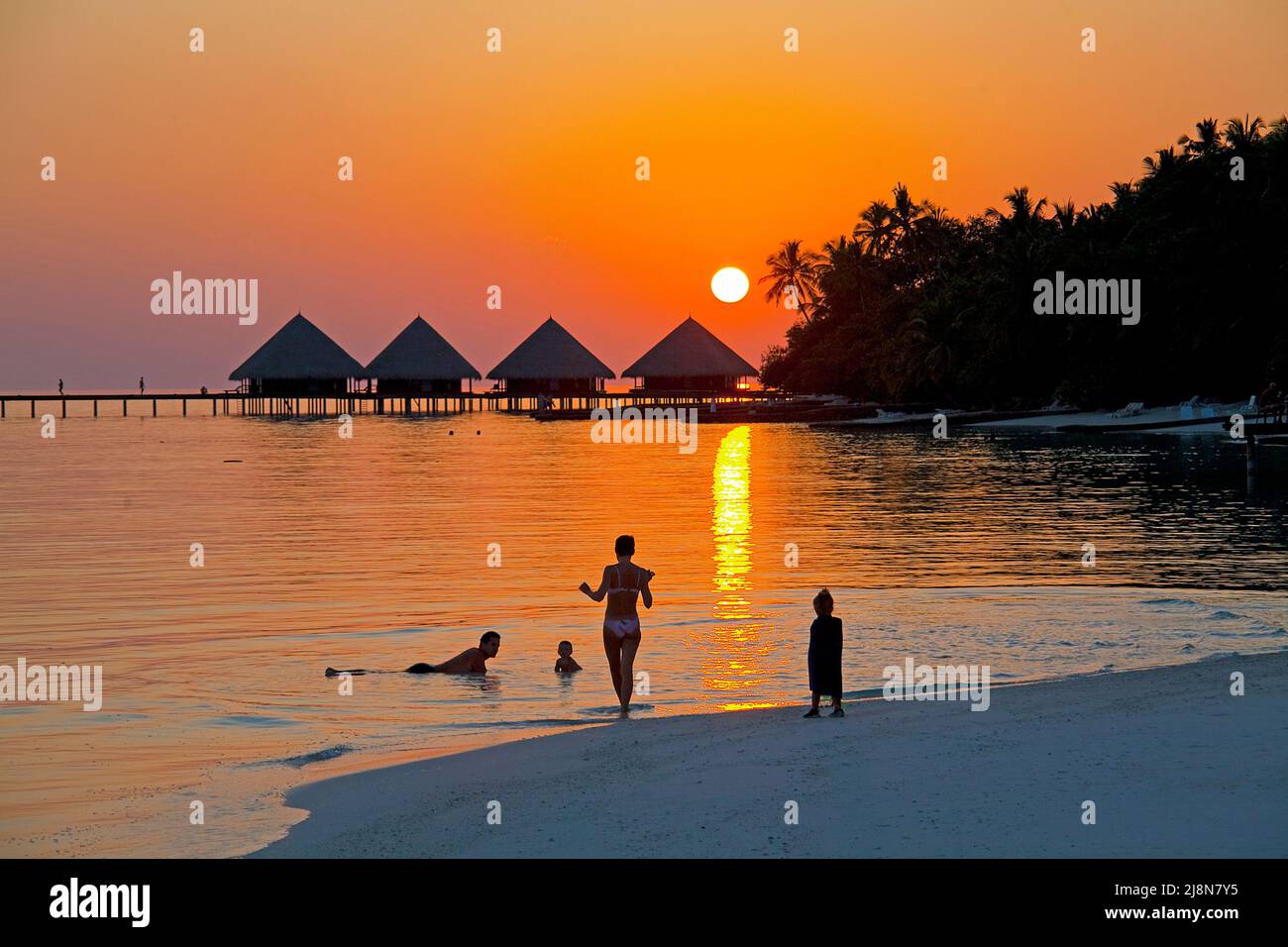 Touristen am Strand geniessen den romantischen Sonnenuntergang hinter den Wasserbungalows, Rannalhi, Sued Male Atoll, Malediven, Indischer Ozean, Asie Foto de stock