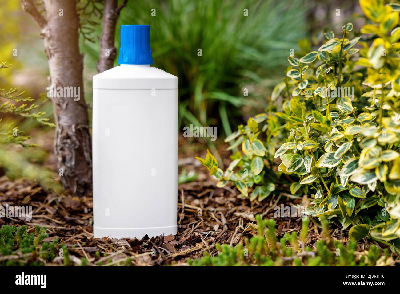 botella de fertilizante blanco para plantas de jardín y flores. espacio de copia de la maqueta Foto de stock