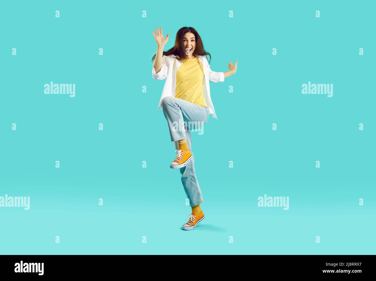 Imagen completa de una mujer joven con ropa elegante e informal saltando  divirtiéndose contra el fondo azul del estudio concepto de emociones  humanas anuncio de estilo de vida de moda juvenil