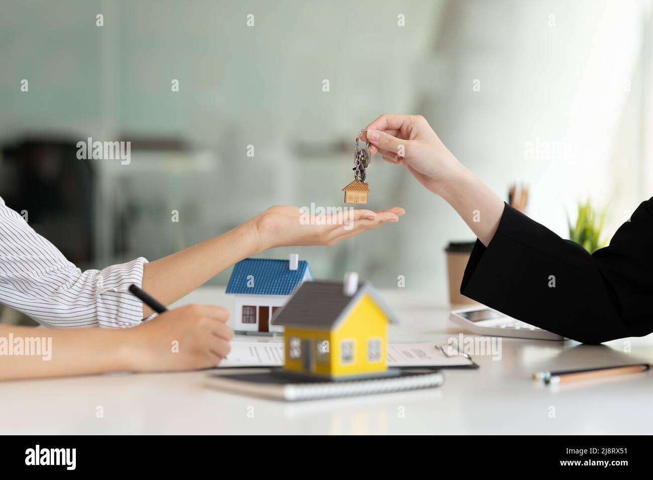 Real estate broker y un apretón de manos al cliente después de la firma de un contrato: real estate, préstamo de vivienda y el concepto de seguros Foto de stock