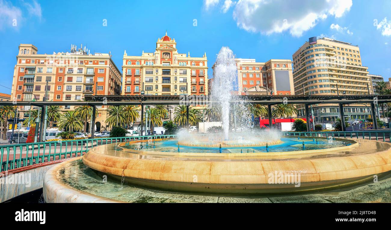 Paisaje urbano panorámico con fuente en la Plaza De La Marina y vista de los edificios en la calle Alameda Principal de Málaga. Andalucía, España Foto de stock