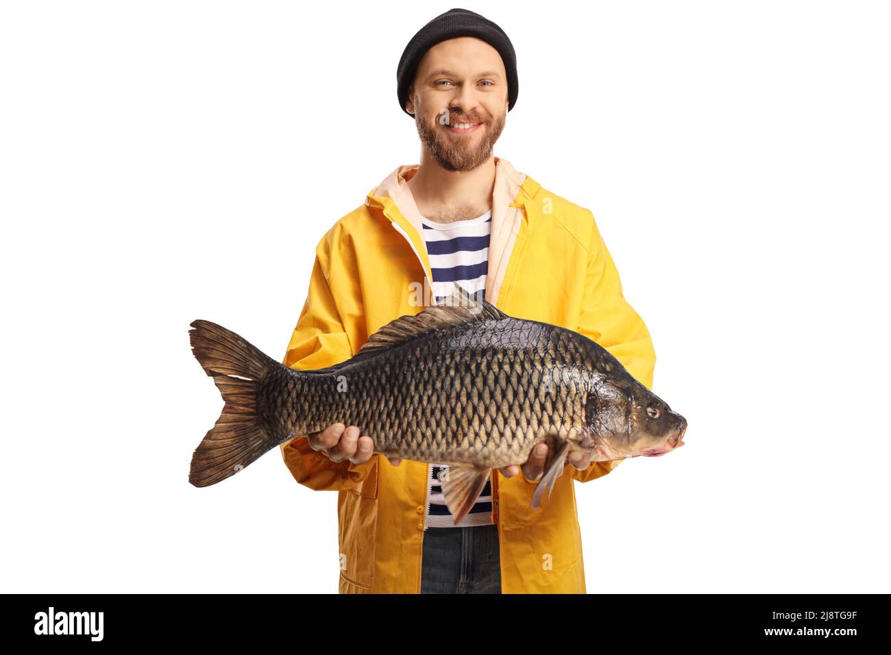 Joven pescador en un chubasquero amarillo que sostiene un pez carpa grande  y sonriente aislado sobre fondo blanco Fotografía de stock - Alamy