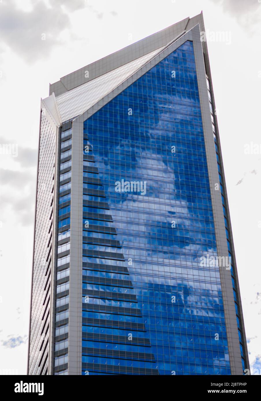 Exterior del edificio Duke Energy con ventanas de vidrio reflectantes contra un cielo nublado y con aspecto eléctrico en el interior de Charlotte, Carolina del Norte. Foto de stock