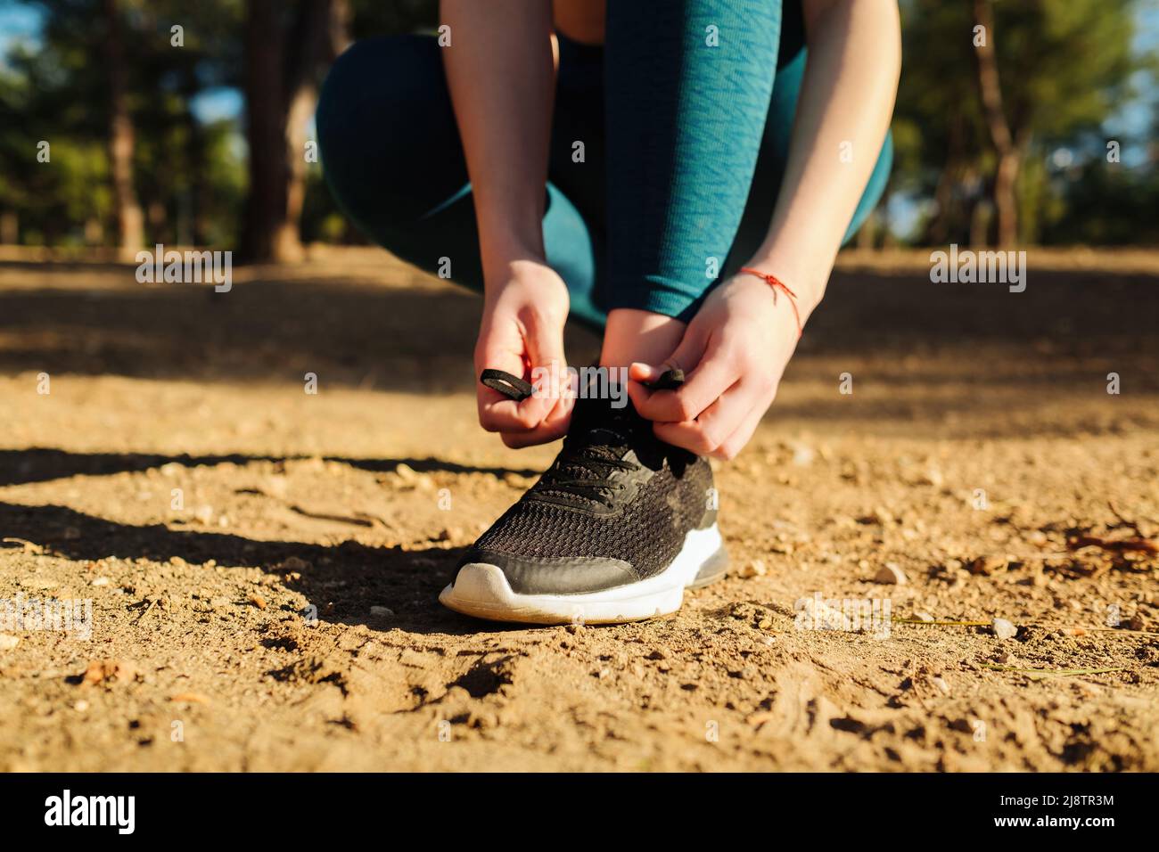 Mujer deportiva lleva zapatillas de running para caminar y correr sobre  fondo verde natural. Atar zapatos para correr, ejercicios de salud y  conceptos de deportes al aire libre Fotografía de stock -