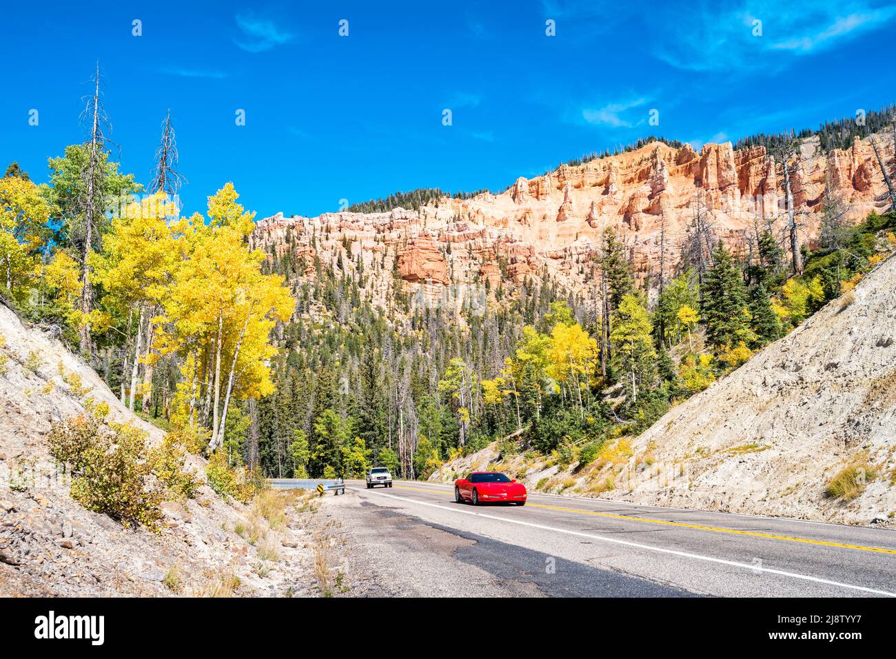 Los coches pasan por el Monumento Nacional de Cedar Breaks, Utah, Estados Unidos, en un día soleado. Foto de stock