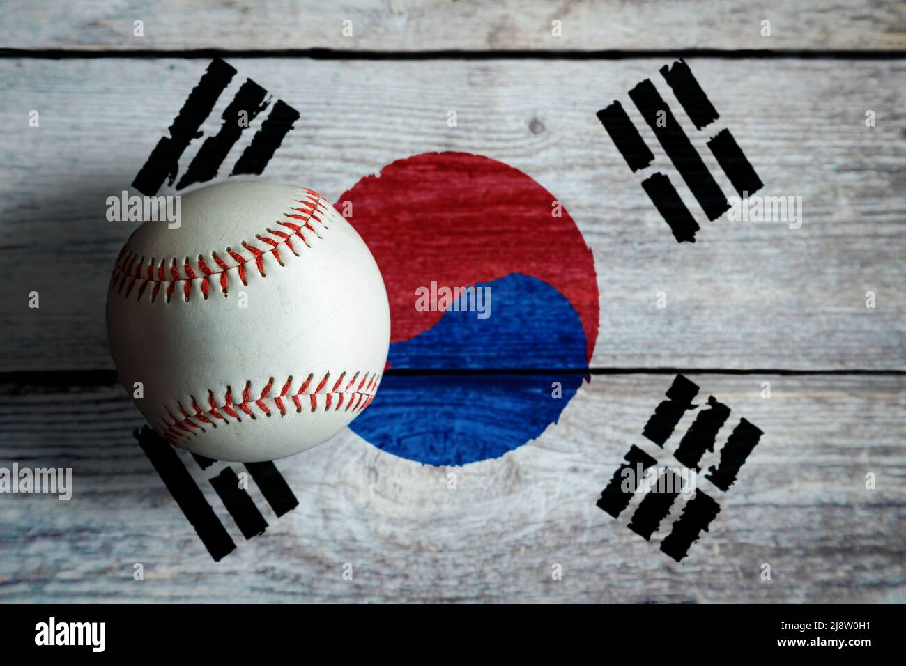 Béisbol de cuero sobre fondo rústico de madera pintado con bandera surcoreana con espacio de copia. Corea del Sur es una de las principales naciones de béisbol en el Wor Foto de stock
