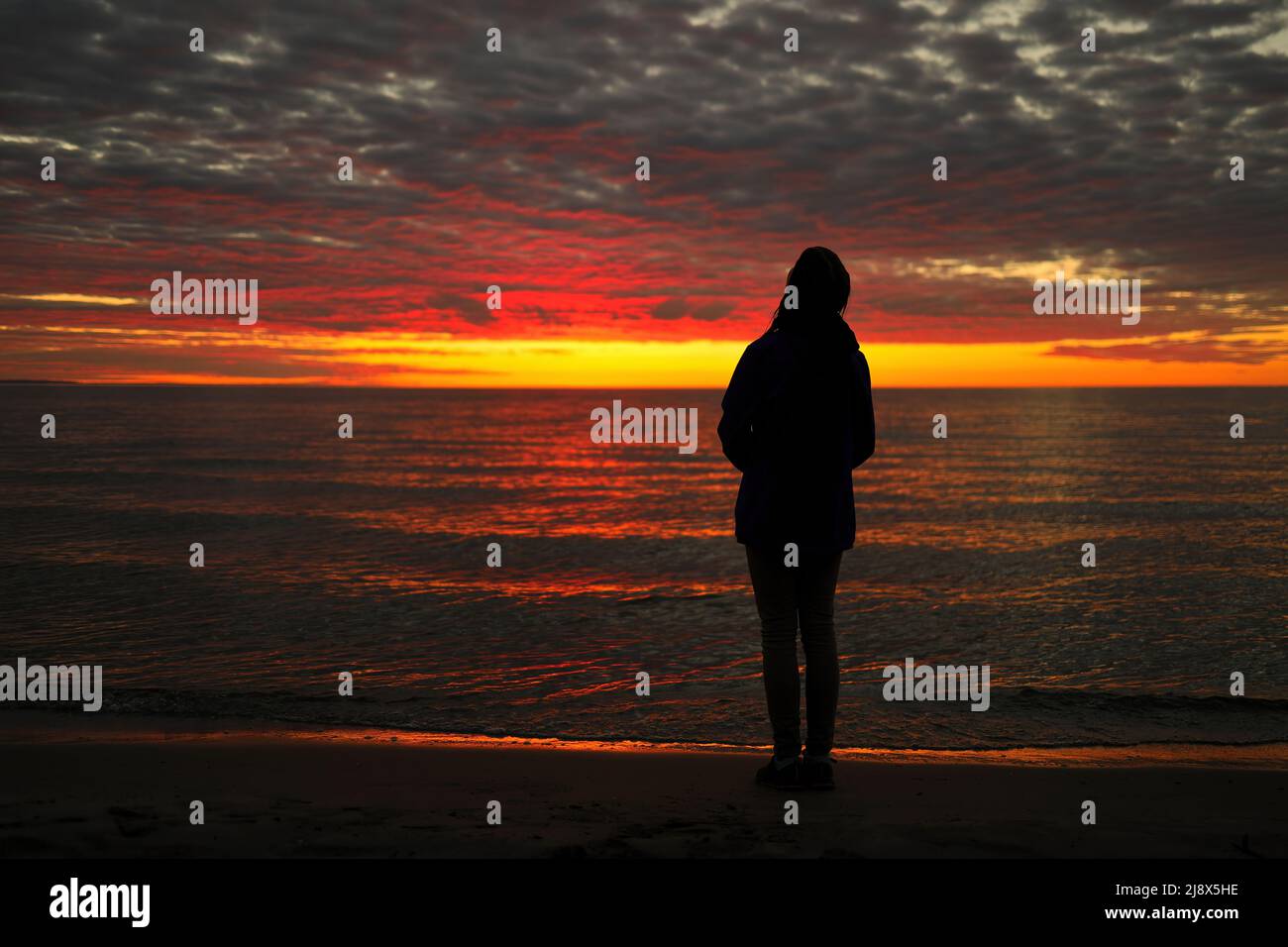 Una joven adolescente mira con asombro, maravilla y admiración a un magnífico Sunset Sky Foto de stock