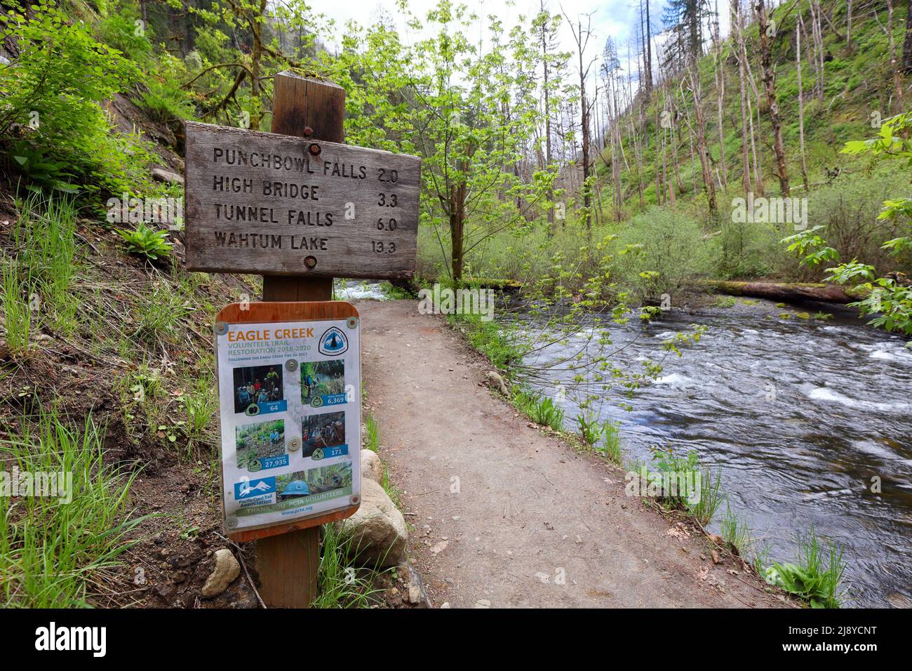 Un cartel que indica la distancia a los lugares de interés en Eagle Creek Trail, Columbia River Gorge, Oregón; con un cartel adicional agradeciendo a los voluntarios por TR Foto de stock