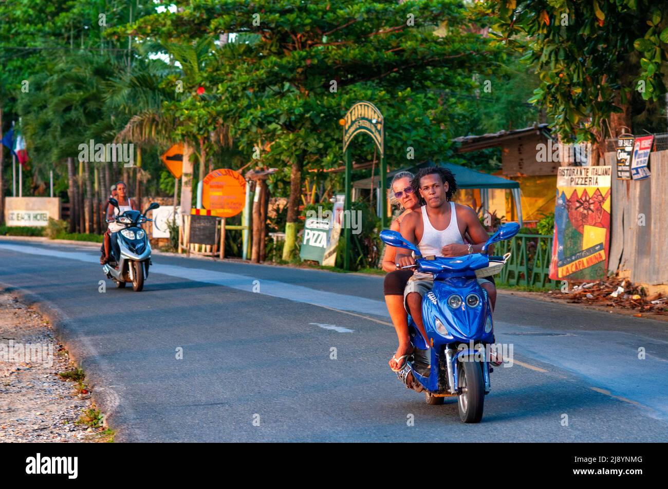 Moto taxi en moto frente a la playa de Las Terrenas, Samana, República Dominicana, Caribe, América. Playa tropical caribeña con palma de coco Foto de stock