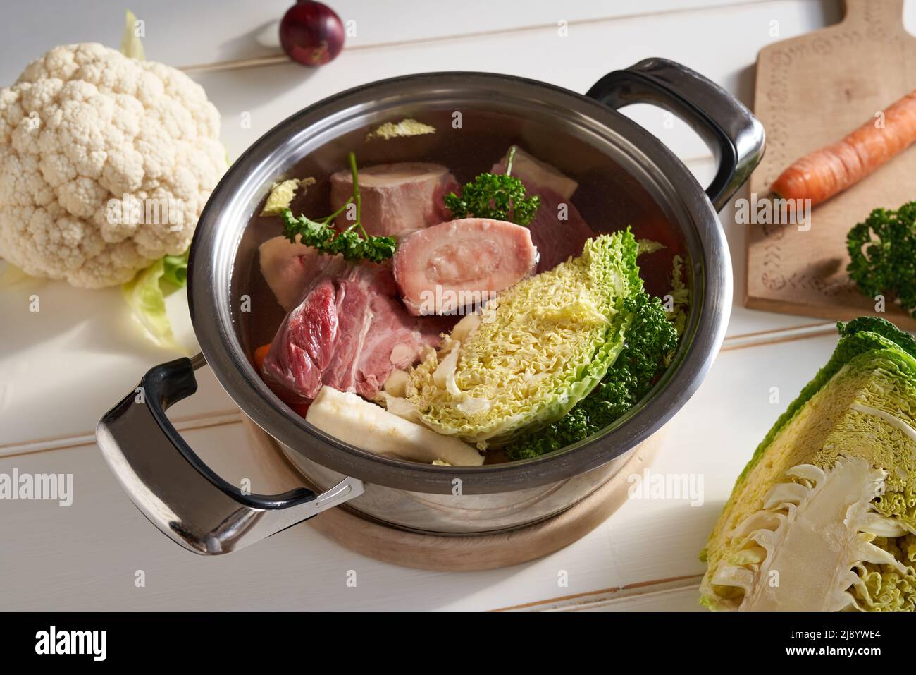 Huesos de médula fresca, carne de res y verduras en una olla de agua