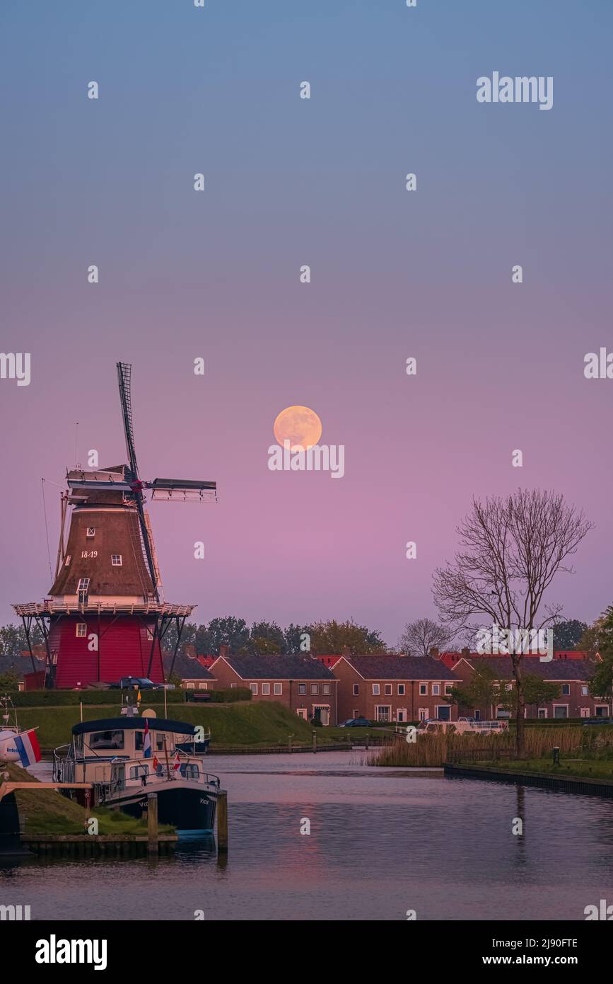 Puesta de sol y puesta de luna llena cerca de Flour Mill 'De Hoop' en la ciudad holandesa de Dokkum, en la provincia de Frisia en la parte norte de la N Foto de stock