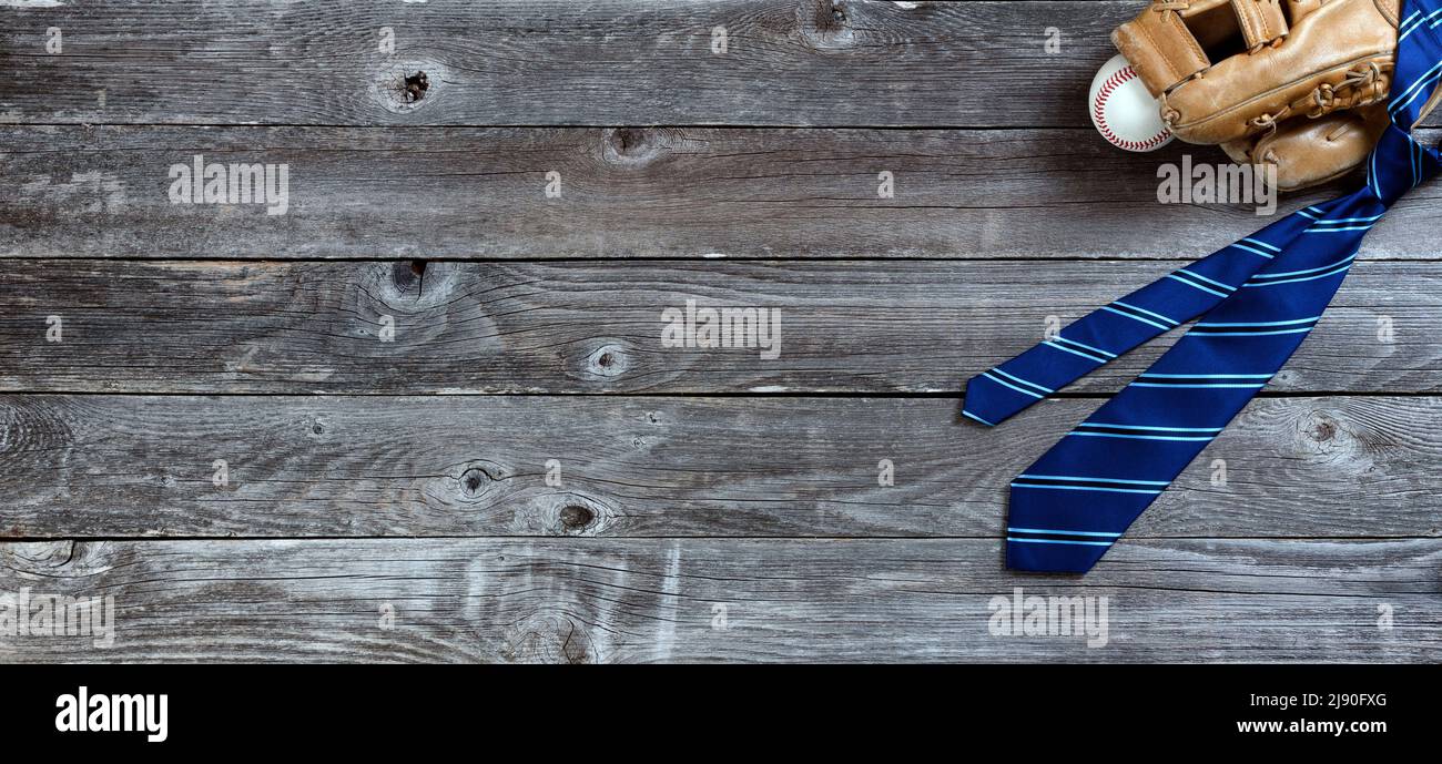 Corbata de vestido pelada azul y guante de béisbol con bola para el concepto de vacaciones del Día de los Padres en madera rústica Foto de stock