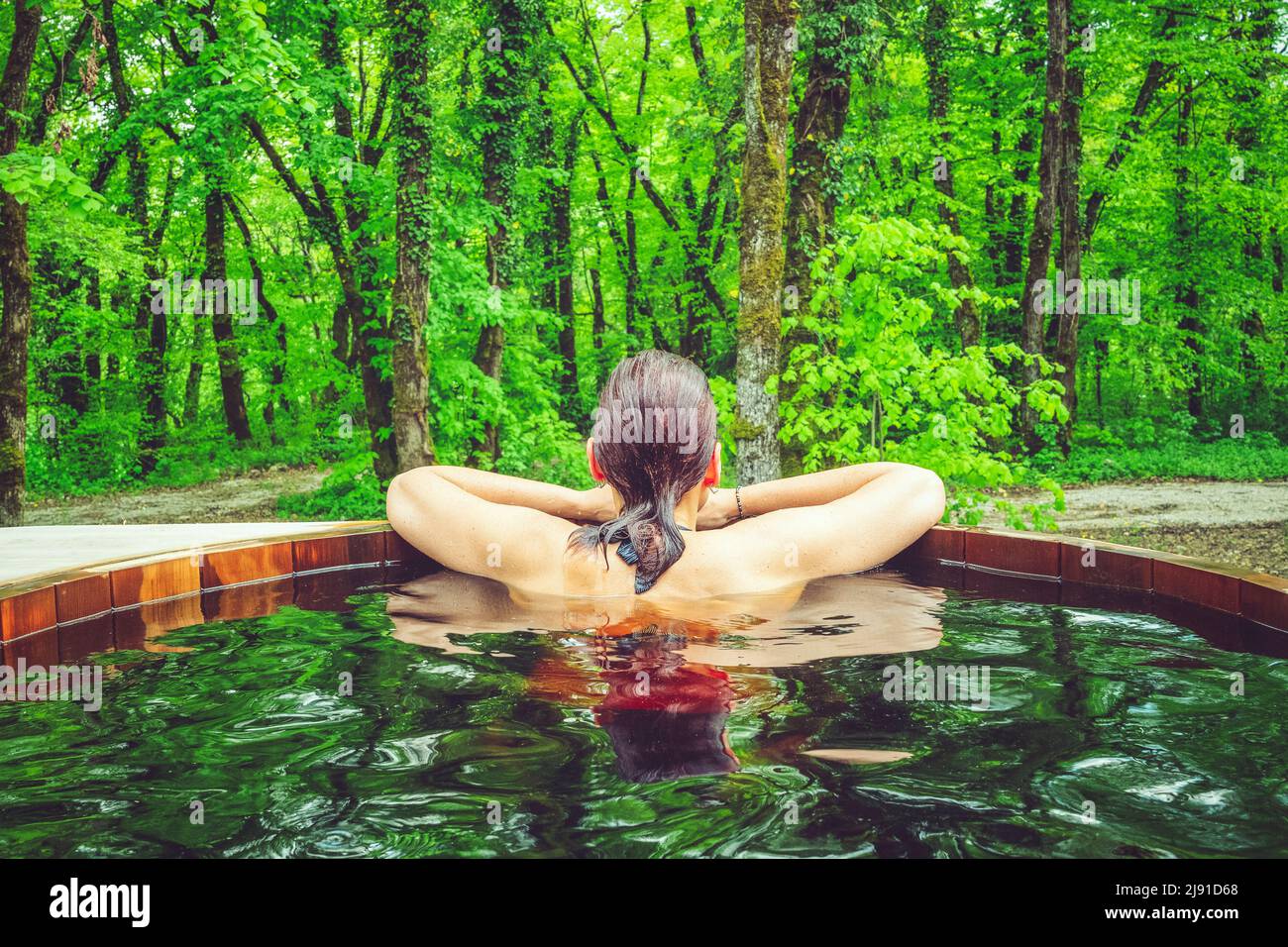 Hermosa mujer en baño nórdico frente a un bosque. Foto de stock
