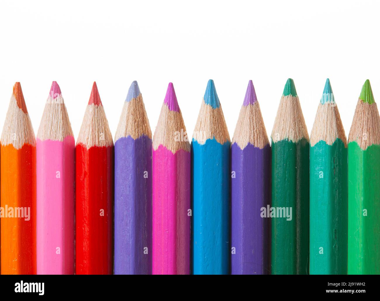 Una fila de lápices de colores sobre fondo blanco Foto de stock