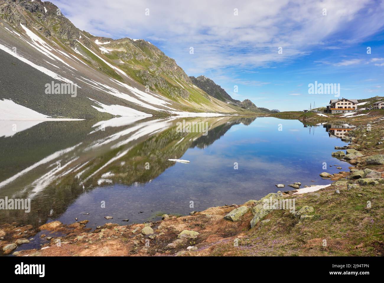 Pintoresco lago alpino con reflejo de montaña en el agua. Lago Lai da la Scotta en el Paso de Flüela en Graubünden, Suiza. Altura 2.384 m, 7.822 pies Foto de stock