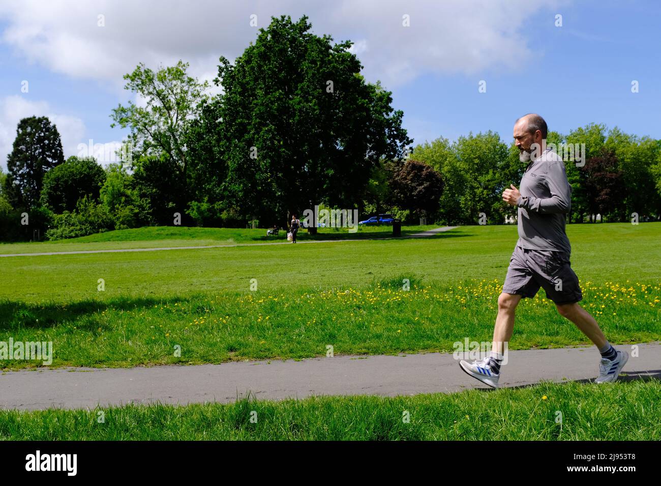 Un hombre de mediana edad corriendo en un parque de Bristol Foto de stock