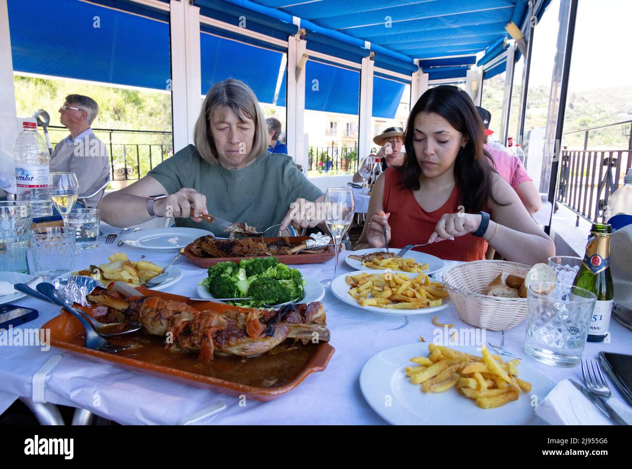 Restaurante español; dos mujeres comiendo carne en un restaurante durante el día, Andalucía, España Europa Foto de stock
