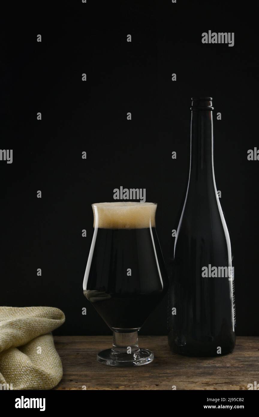 Botella de una copa de cerveza negra artesanal con sabor a chocolate Foto de stock