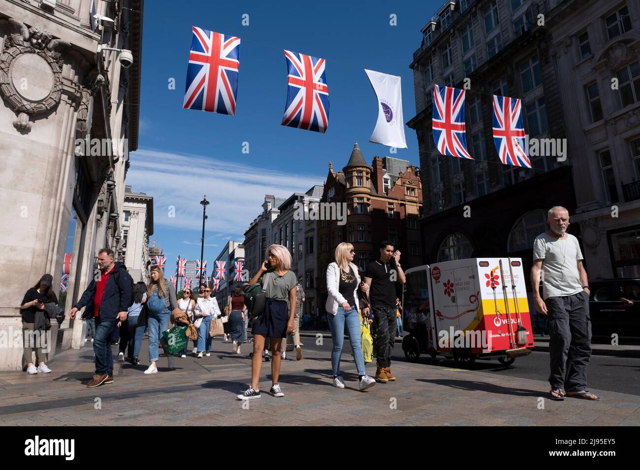 Union Flags colgando en lo alto de Oxford Street mientras los compradores, visitantes y londinenses pasan por la celebración de la Reina Elizabeth IIS próximo Jubileo Platino el 17th de mayo de 2022 en Londres, Reino Unido. En 2022, Su Majestad la Reina Isabel II se convertirá en el primer monarca británico en celebrar un jubileo de platino con motivo del 70th aniversario de su adhesión al trono el 6 de febrero de 1952. Oxford Street es un importante centro comercial en el extremo oeste de la capital y es la calle comercial más concurrida de Europa, con alrededor de medio millón de visitantes diarios a sus aproximadamente 300 tiendas, la mayoría de las cuales lo son Foto de stock
