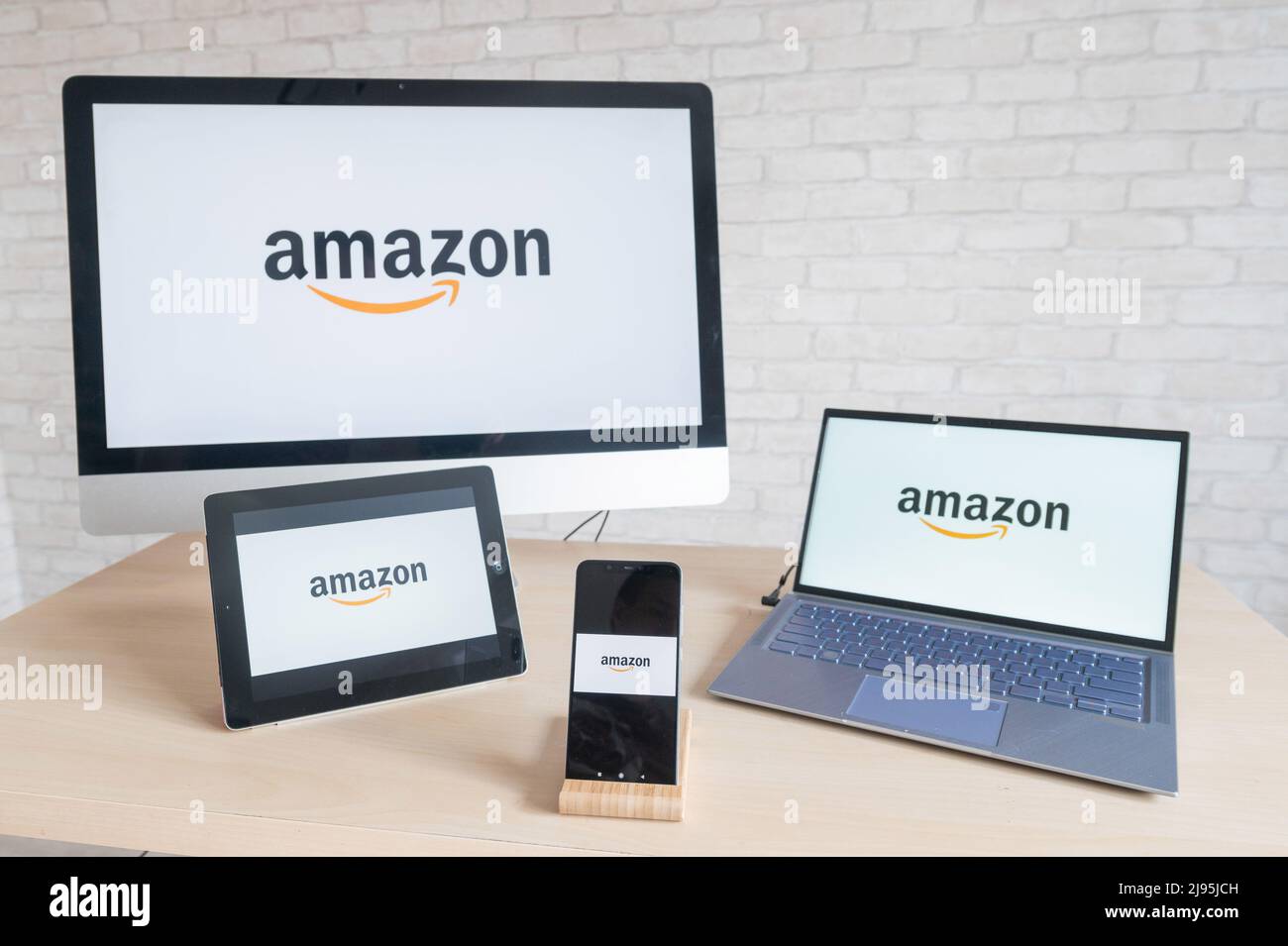 Logotipo de Amazon en las pantallas del ordenador, tableta digital portátil  y smartphone. Aplicaciones para todos los dispositivos tienda en línea  donde se puede comprar todo. En línea Fotografía de stock -