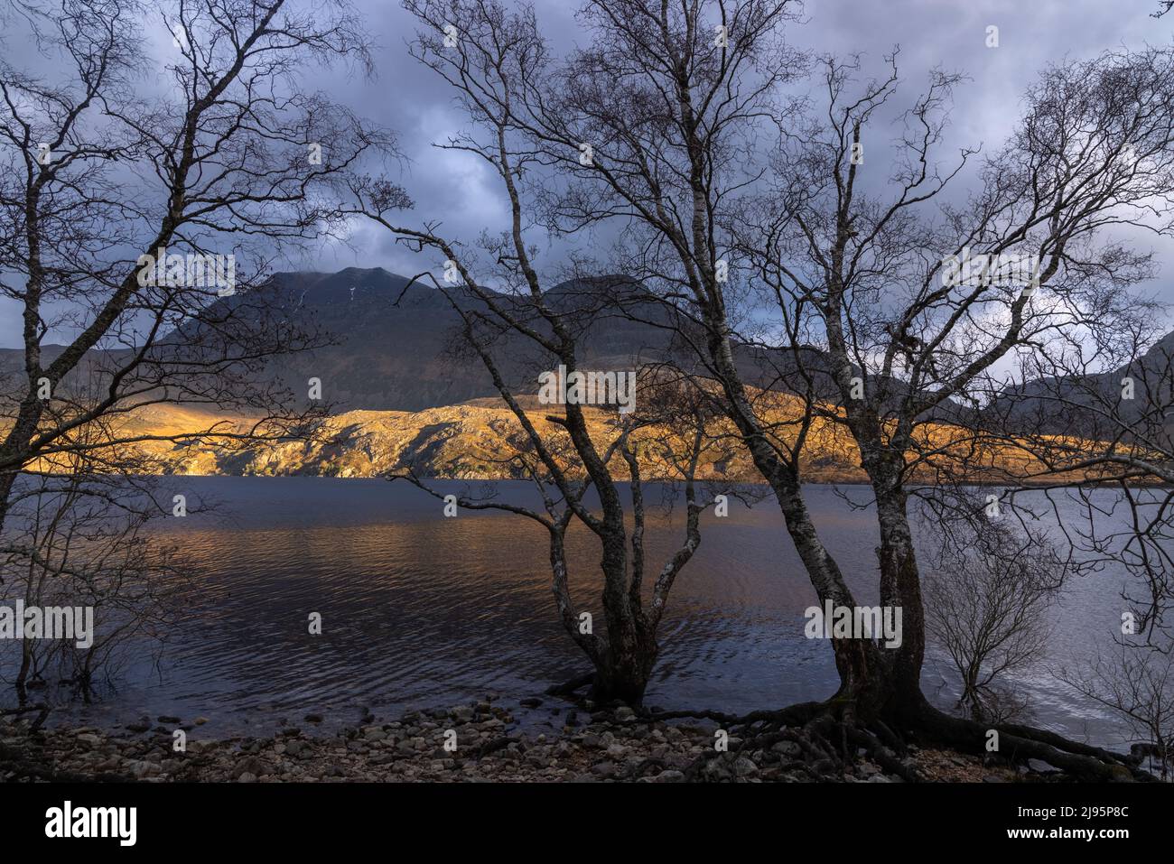 Un eje de luz de invierno baja en Loch Maree y Slioch, Wester Ross, Escocia, Reino Unido Foto de stock