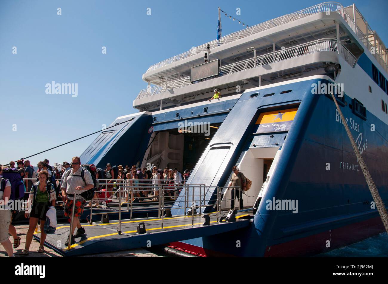 Un gran grupo de turistas desembarcan de un ferry en el puerto de la isla en Grecia. Concepto de turismo turístico Foto de stock