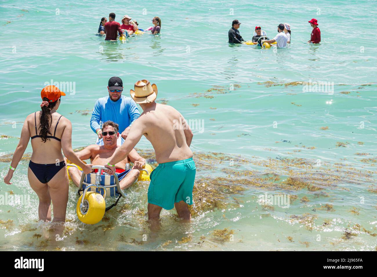 Miami Beach Florida, Sabrina Cohen Adaptive Beach Day, discapacitados necesidades especiales ruedas de agua para discapacitados, silla de ruedas flotante, hombre hispano mujer masculina Foto de stock