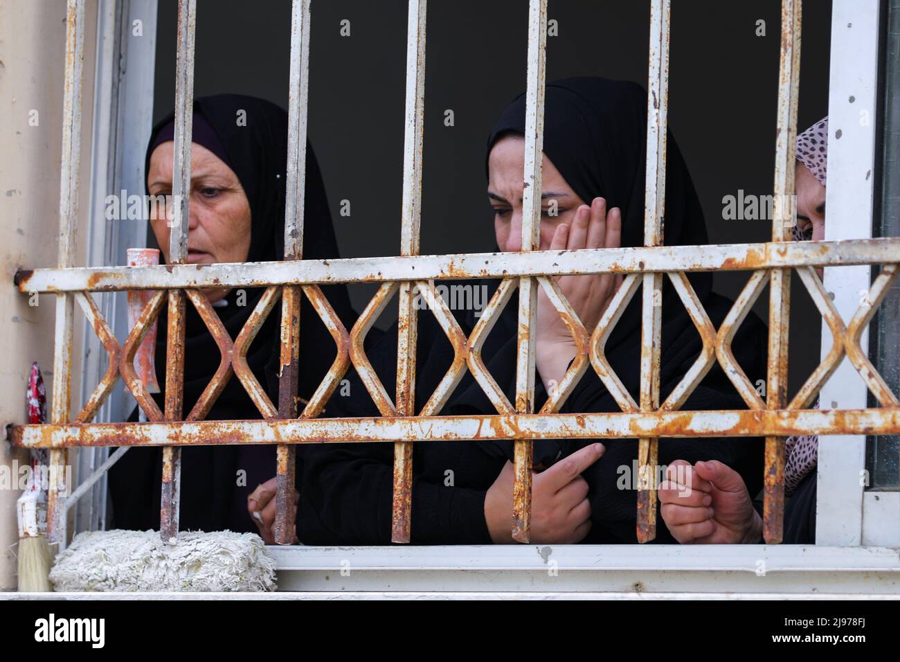 Familiares del militante palestino Amjad Al Fayed, que murió en enfrentamientos durante una redada israelí, asisten a su funeral desde una ventana en Jenin, en la Ribera Occidental ocupada por Israel, el 21 de mayo de 2022. REUTERS/Raneen Sawafta Foto de stock