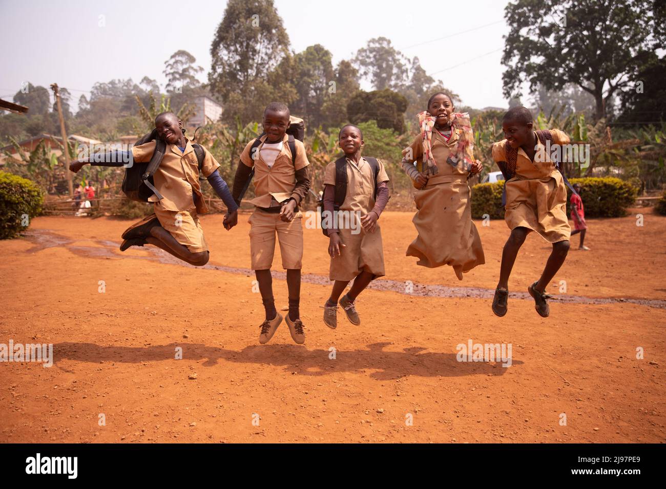 Grupo de niños africanos jugando y saltando arriba y abajo en el patio escolar. Jugando juntos. Foto de stock