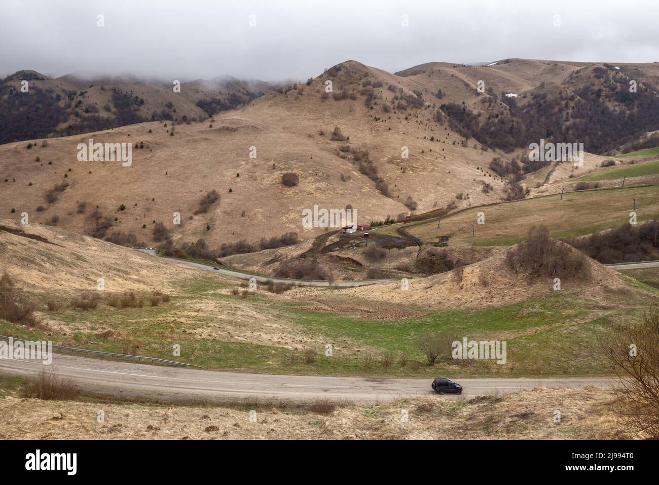 Camino serpentín hasta el paso de Gum-Bashi. Cáucaso Norte, Karachay-Cherkessia. Paisaje de montaña con nubes bajas Foto de stock