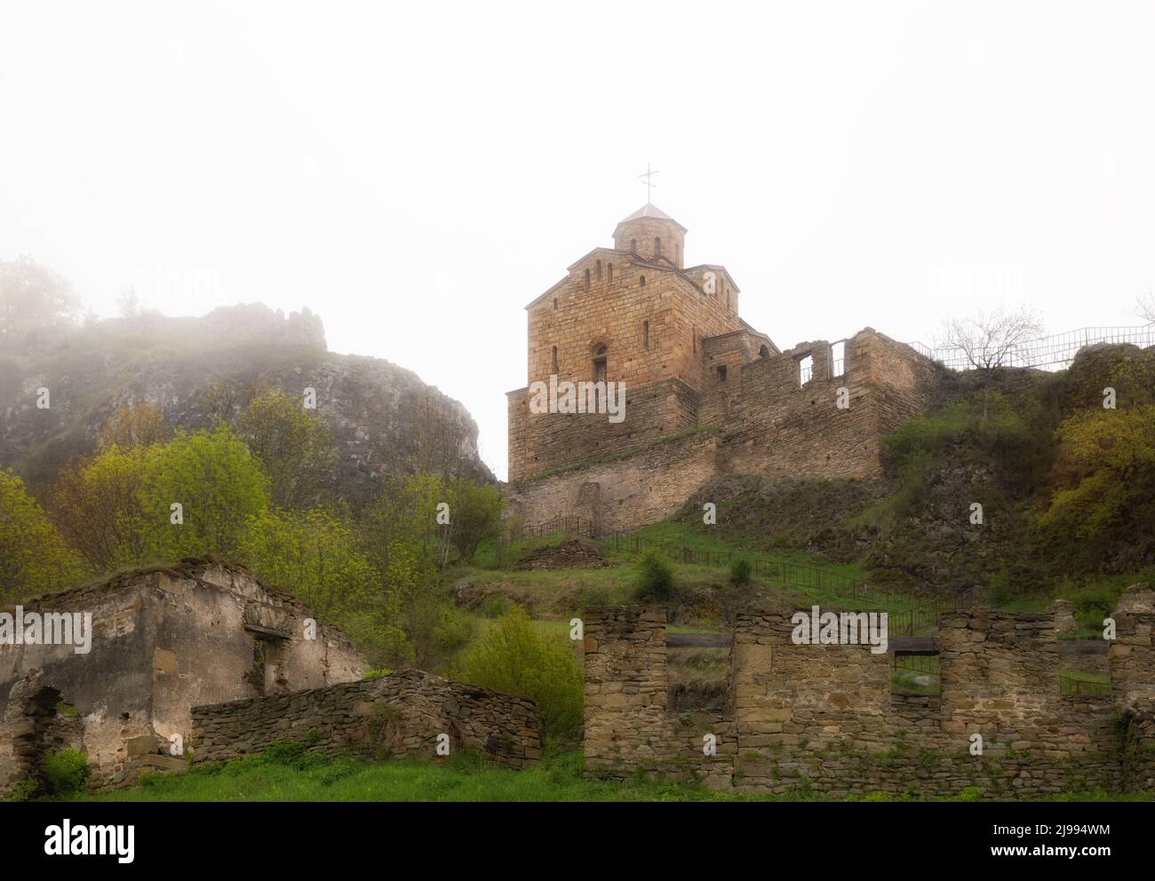 Antigua iglesia Shoana del siglo 10th en las montañas en densa niebla Foto de stock